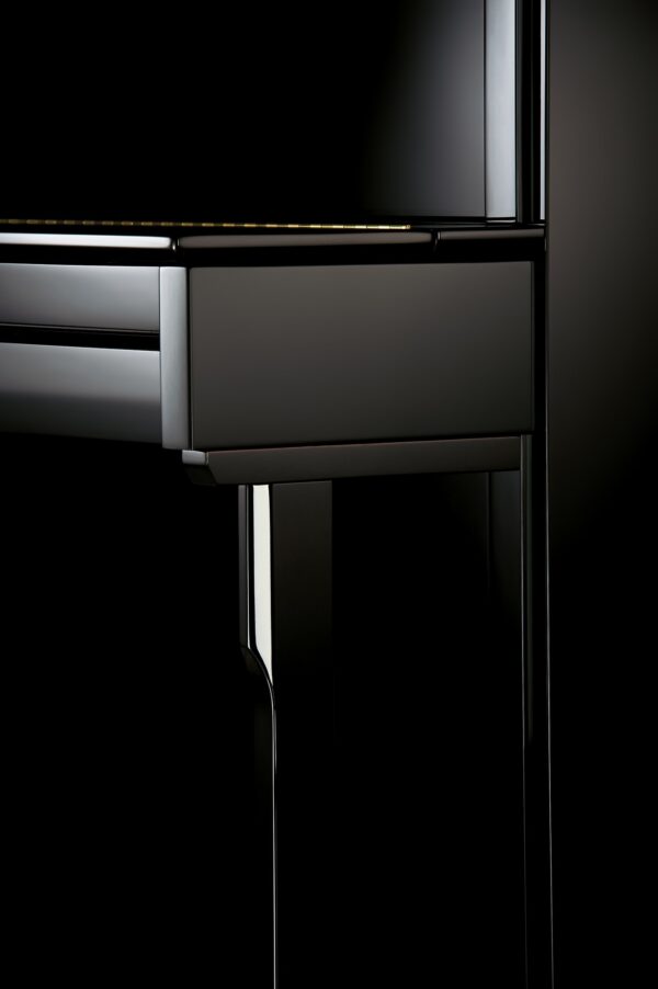 Détail d'un piano noir moderne et brillant.
